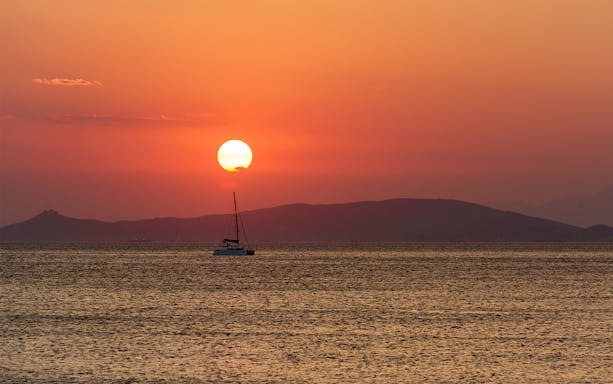 Sailboat on the sea at sunset in Athens Riviera, Greece.