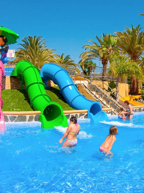 Children playing near colorful water slides at Aqualand Maspalomas.