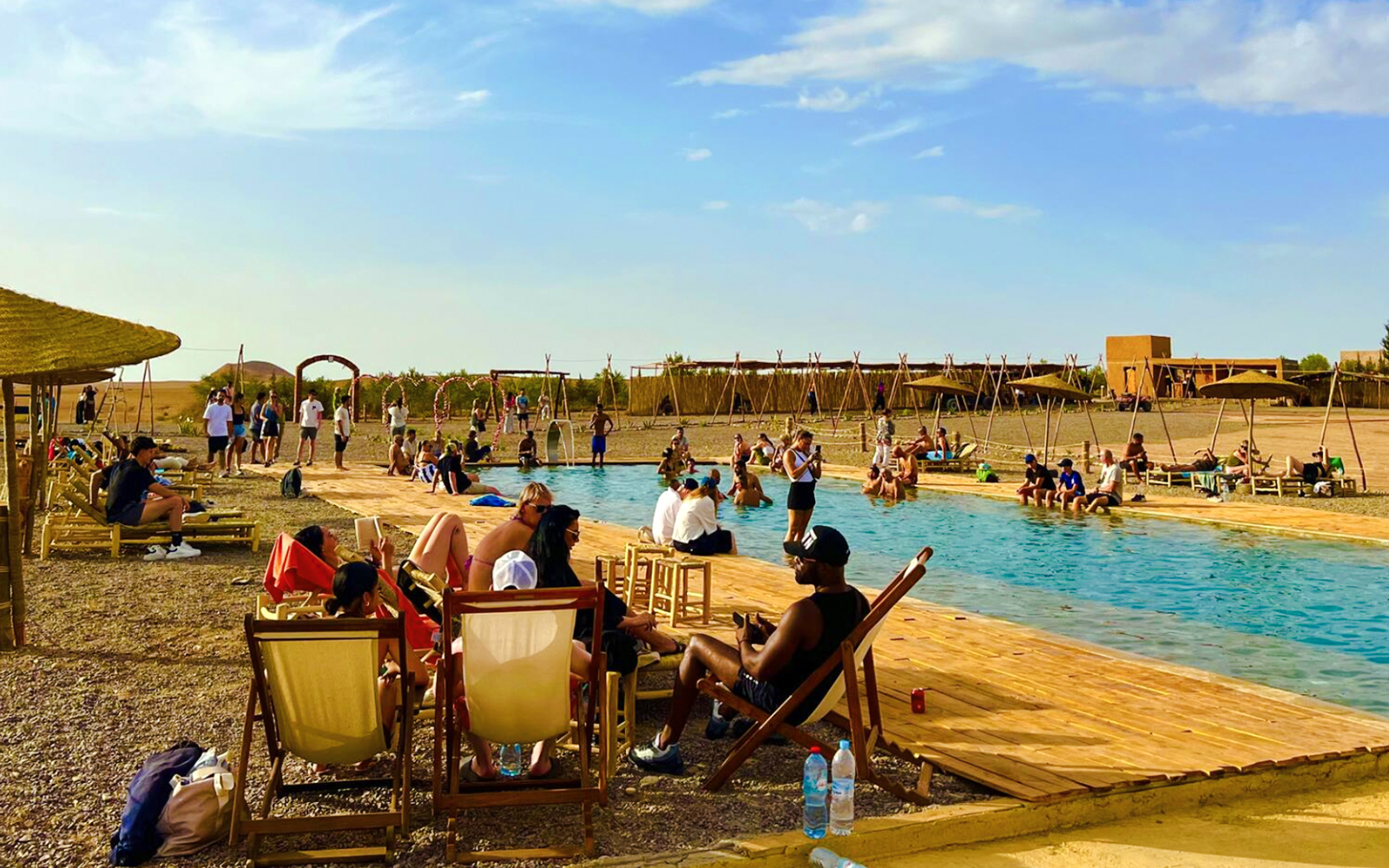 People relaxing by a pool in Agafay Desert, Marrakesh.