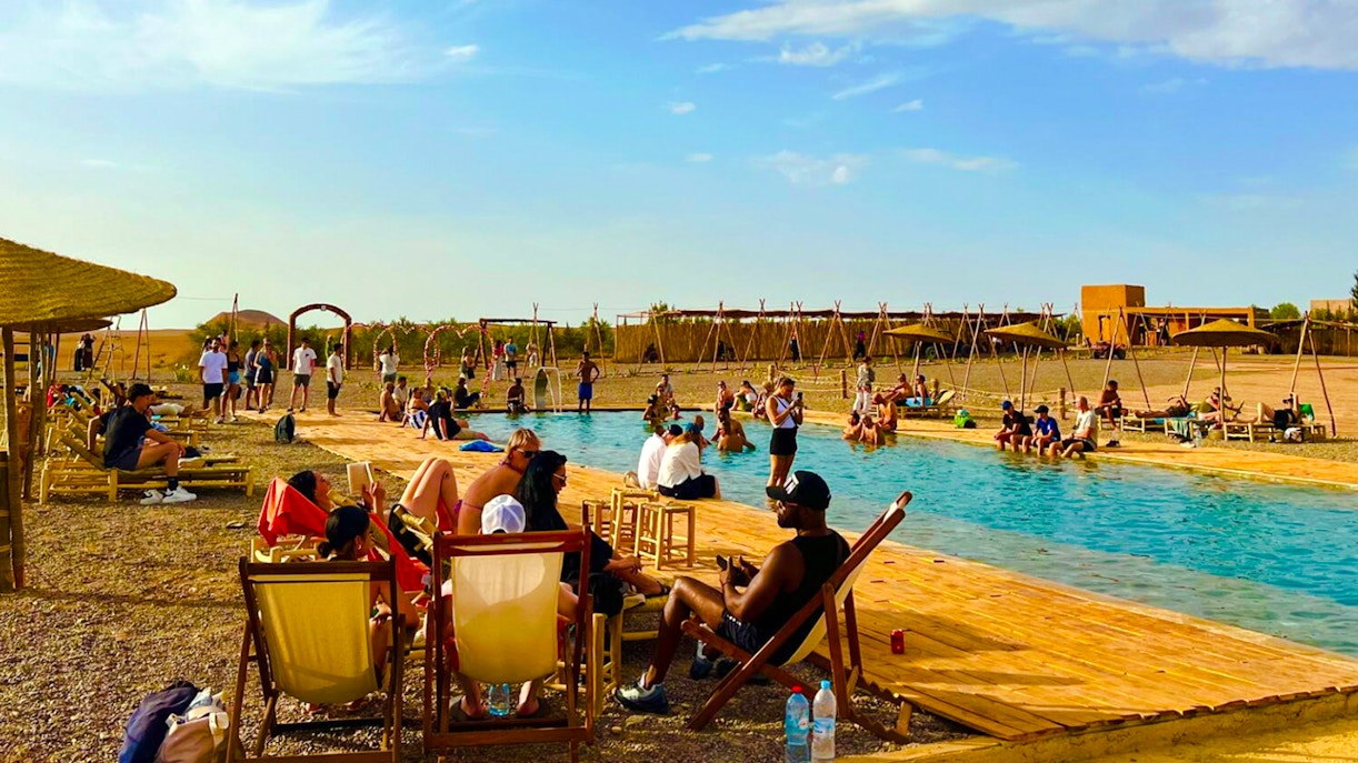 People relaxing by a pool in Agafay Desert, Marrakesh.