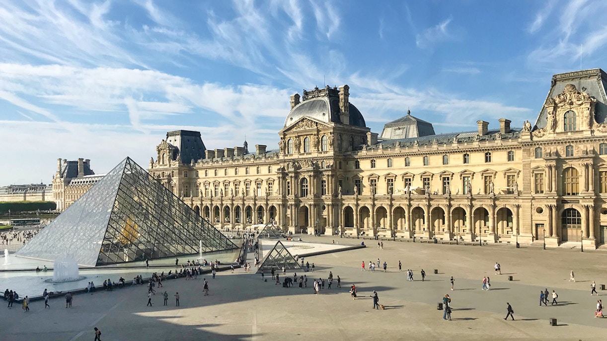 Louvre Museum glass pyramid entrance in Paris, France.