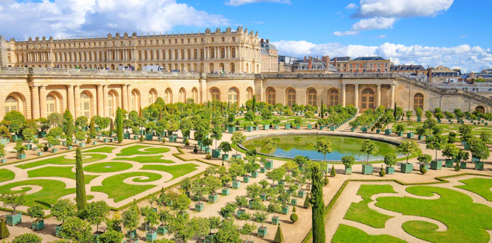 Versailles Orangery gardens with manicured lawns and citrus trees, France.