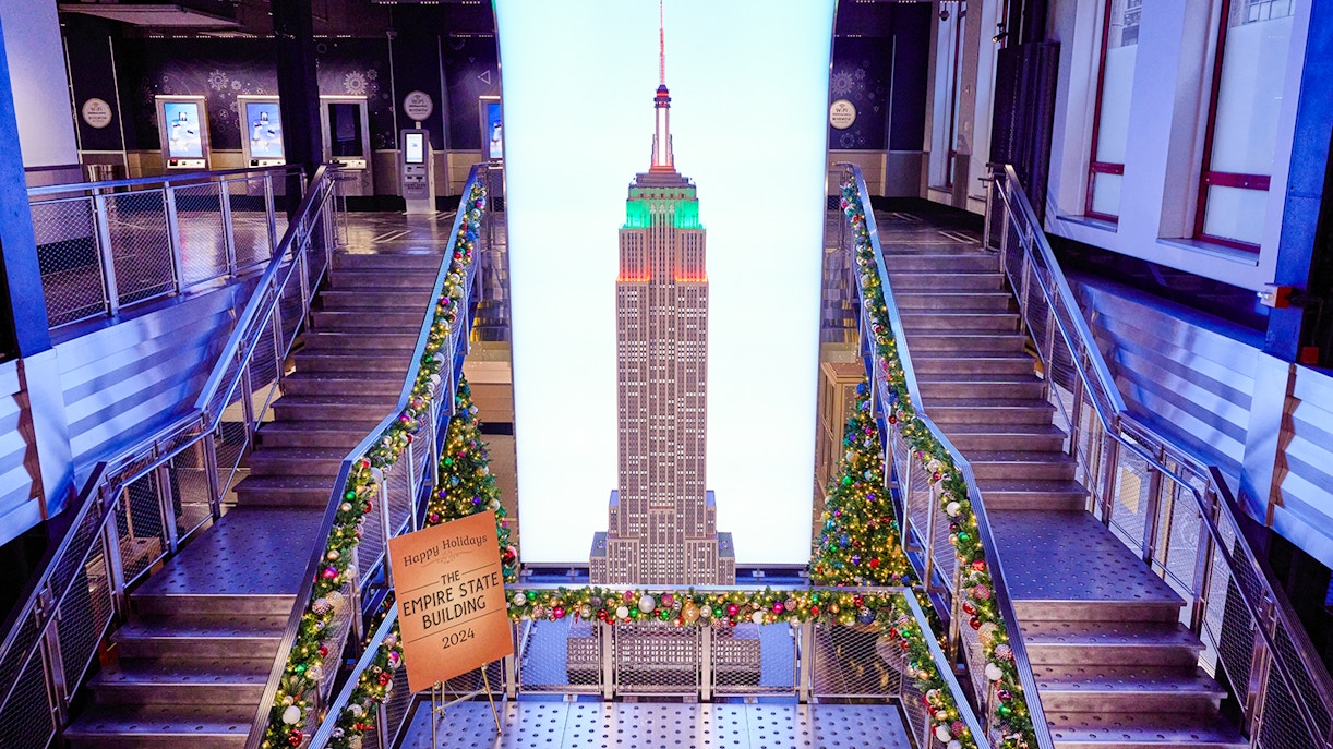Empire State Building interior with Christmas decorations and model display.
