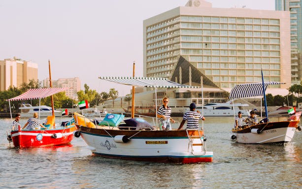 Boats on Dubai Creek with modern skyscrapers in the background during the New Dubai Skyscrapers Tour.