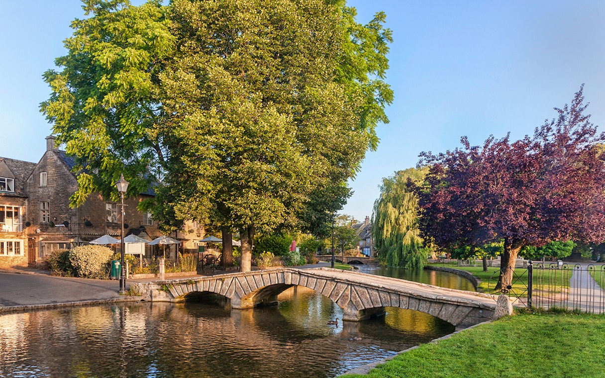 Stone bridge over river in Cotswolds village, part of Blenheim Palace and Downton Abbey tour.