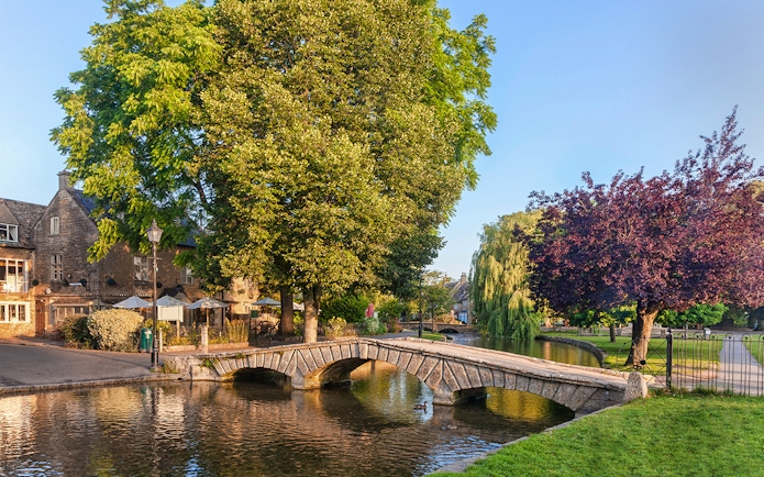 Stone bridge over river in Cotswolds village, part of Blenheim Palace and Downton Abbey tour.
