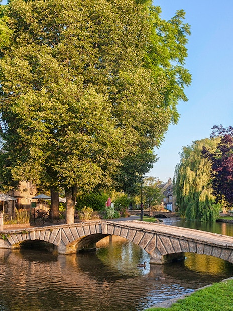 Stone bridge over river in Cotswolds village, part of Blenheim Palace and Downton Abbey tour.
