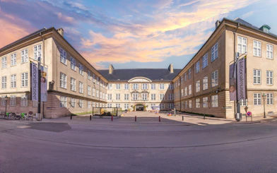 Exterior view of The National Museum of Denmark in Copenhagen with banners and courtyard.