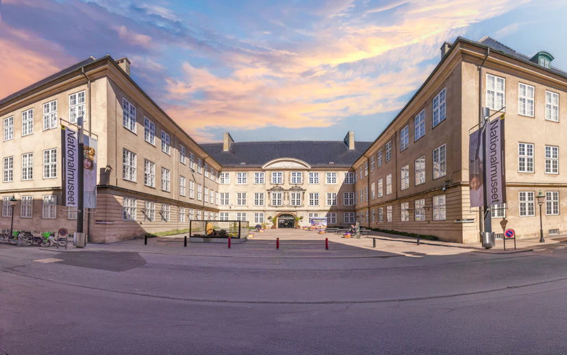 Exterior view of The National Museum of Denmark in Copenhagen with banners and courtyard.