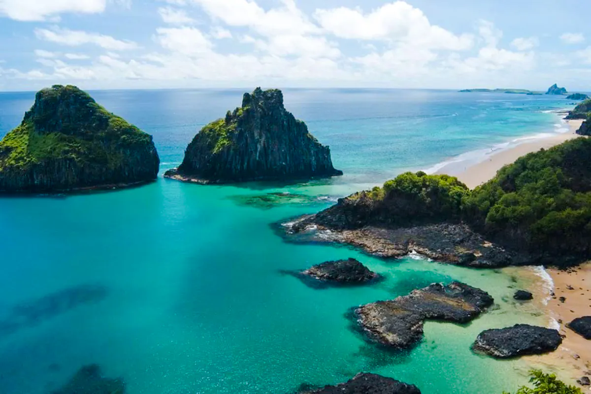 Sancho Beach and Porcos Bay with turquoise waters and rocky cliffs, Noronha Island tour.