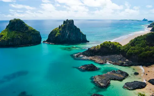 Sancho Beach and Porcos Bay with turquoise waters and rocky cliffs, Noronha Island tour.