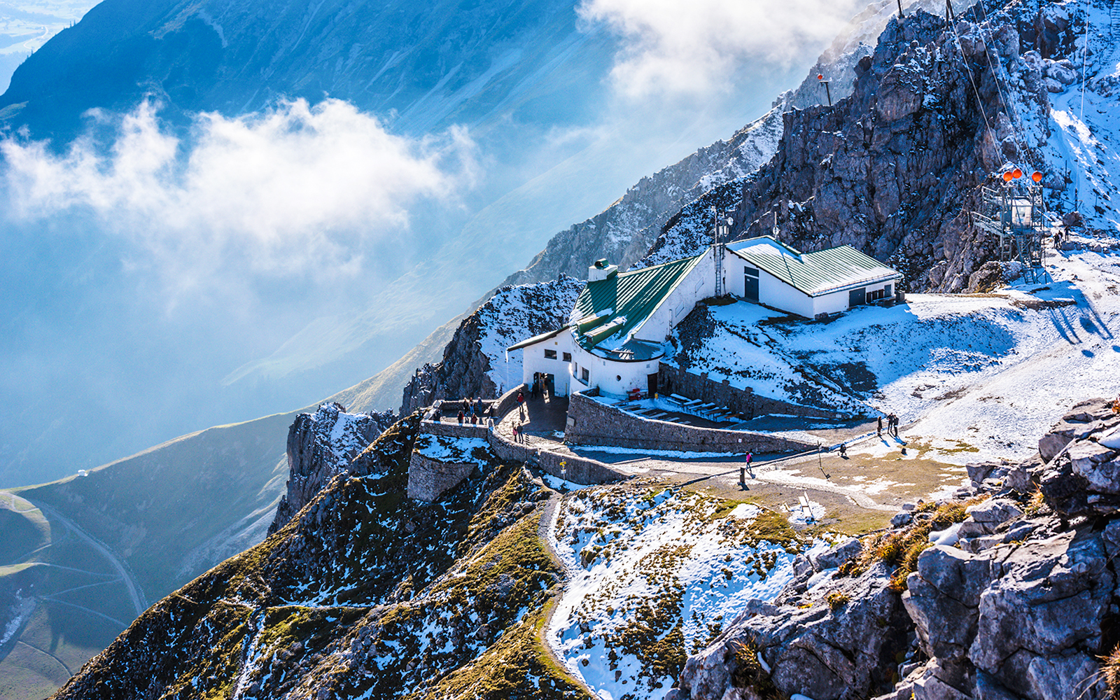 Hafelekar mountain station in Austria with snowy peaks and visitors exploring.