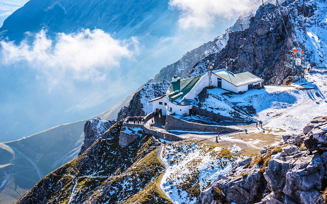 Hafelekar mountain station in Austria with snowy peaks and visitors exploring.