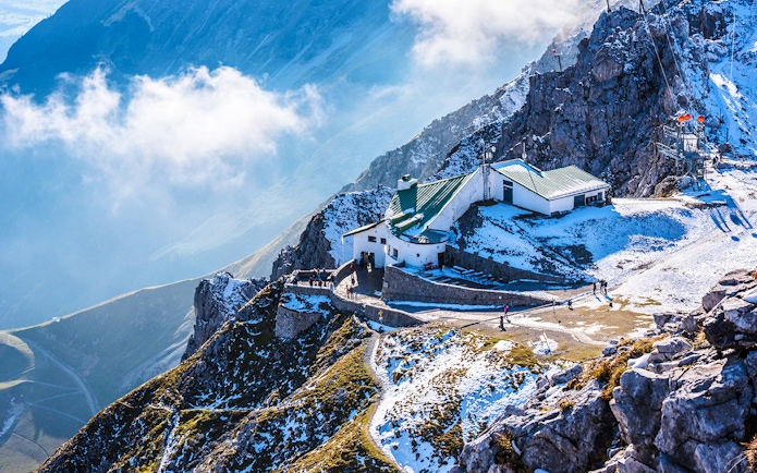Hafelekar mountain station in Austria with snowy peaks and visitors exploring.