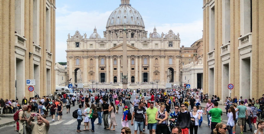 Crowd in St. Peter's Square, Vatican City, with St. Peter's Basilica in the background.