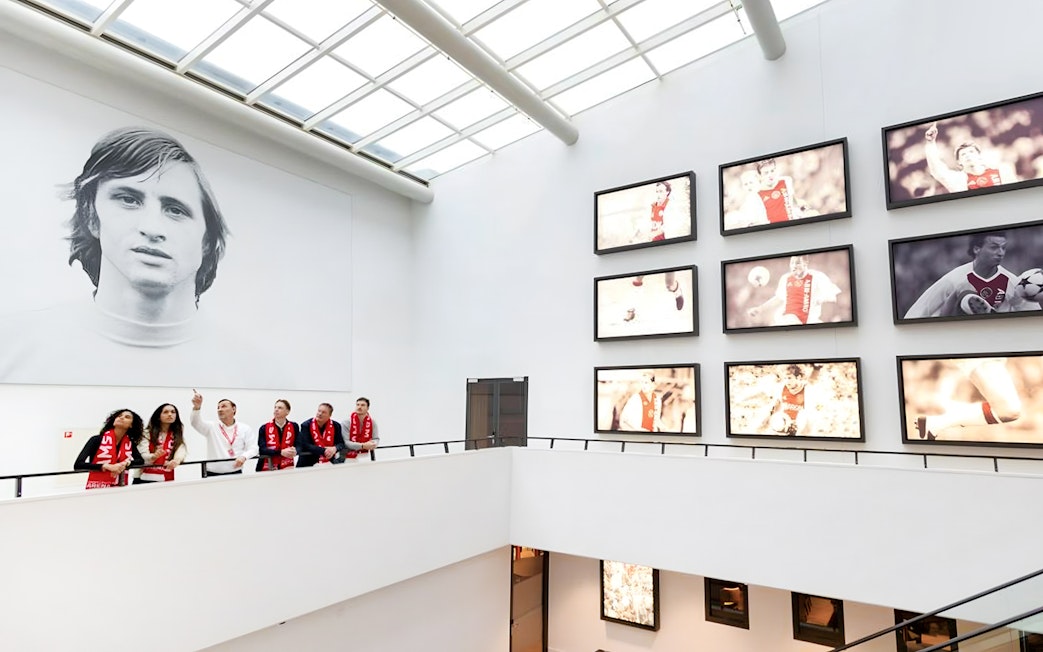 Visitors on a VIP tour at Johan Cruijff ArenA, Amsterdam, viewing football memorabilia.