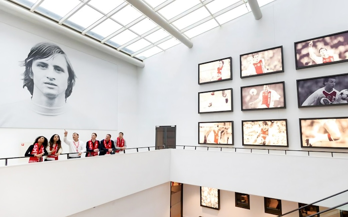 Visitors on a VIP tour at Johan Cruijff ArenA, Amsterdam, viewing football memorabilia.