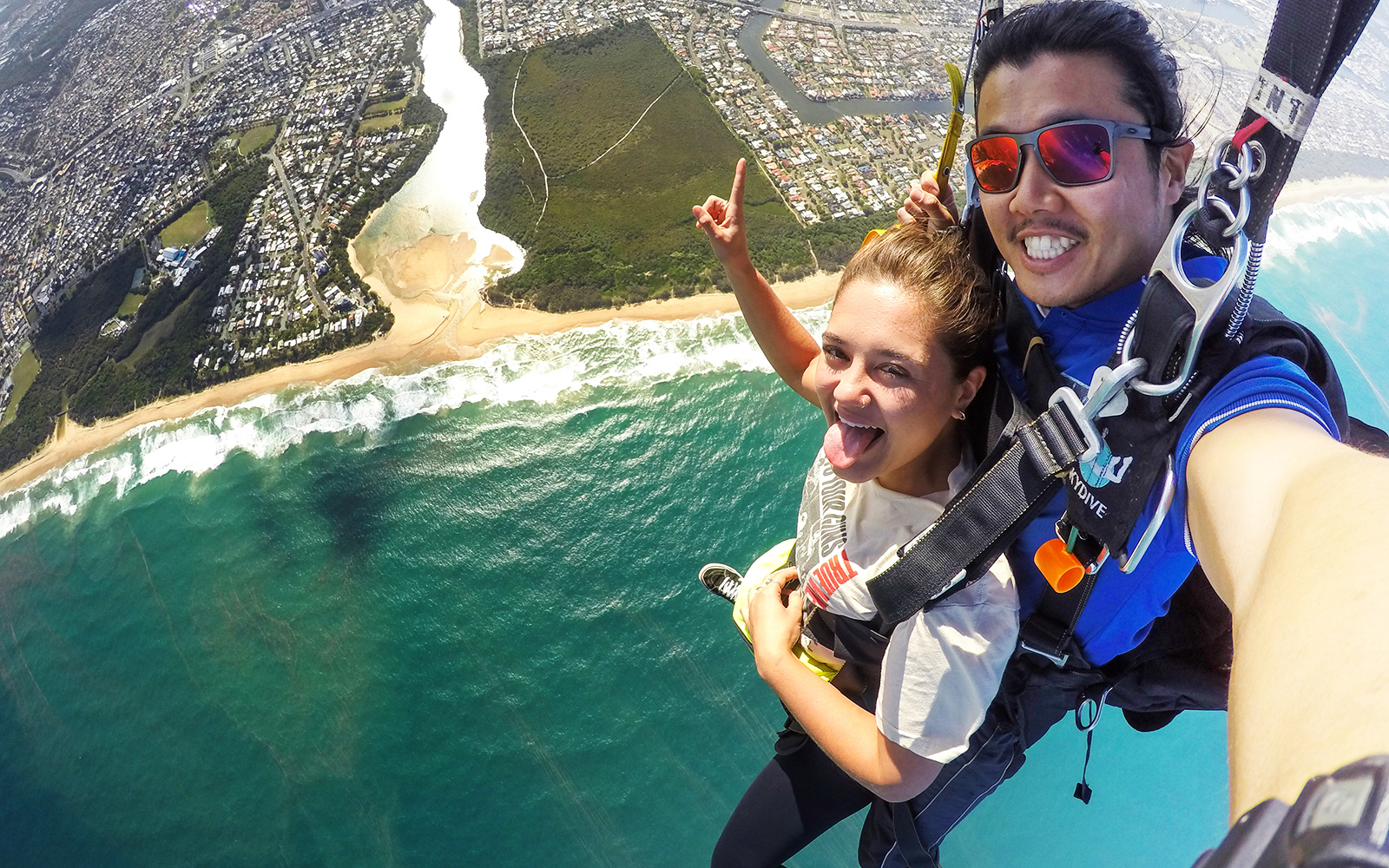 Tandem skydive over Sunshine Coast Beach with ocean and coastline view.