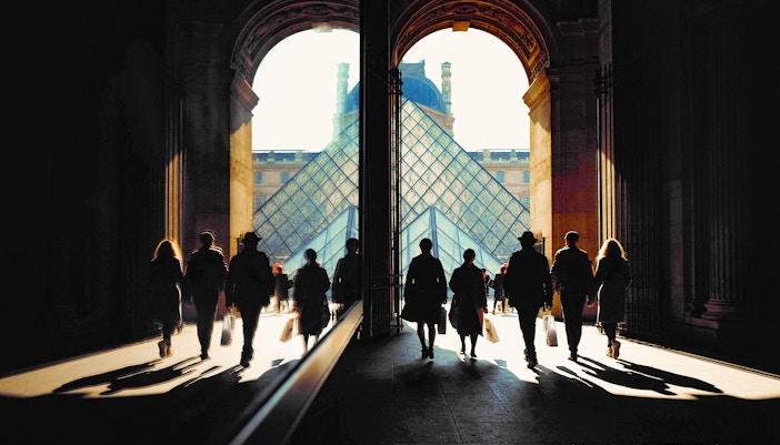 Louvre Museum Richelieu Passage entrance in Paris with visitors exploring the historic architecture.