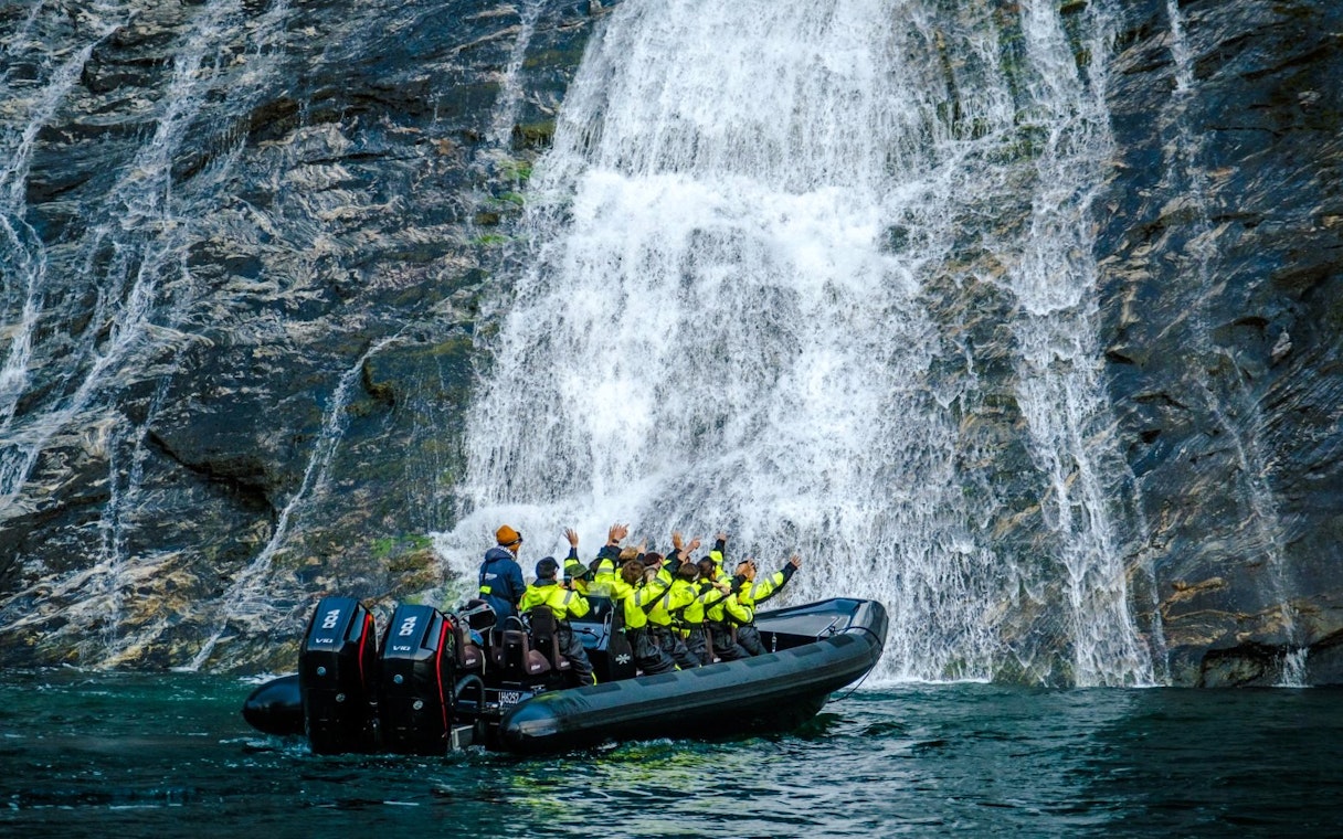RIB boat near Hellesylt waterfall on Geiranger Fjord safari.
