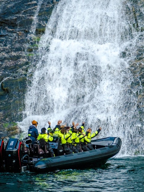 RIB boat near Hellesylt waterfall on Geiranger Fjord safari.
