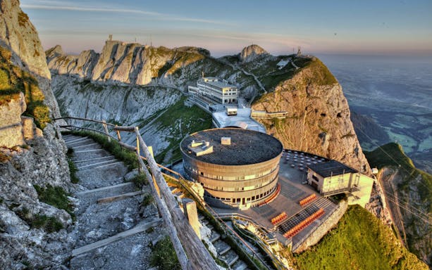 Panoramic view of Mount Pilatus with a mountain path and round building in Switzerland.