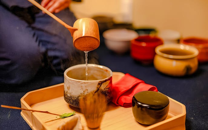 Pouring water into a tea bowl during a private tea ceremony with seasonal wagashi in Japan.