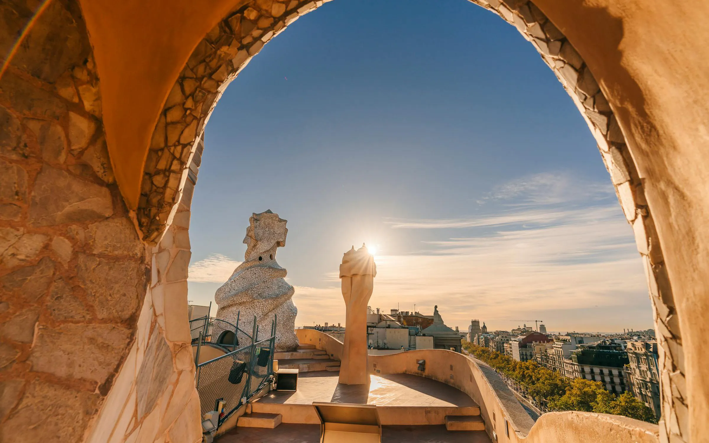 Rooftop sculptures at La Pedrera, Barcelona, with sunset view.