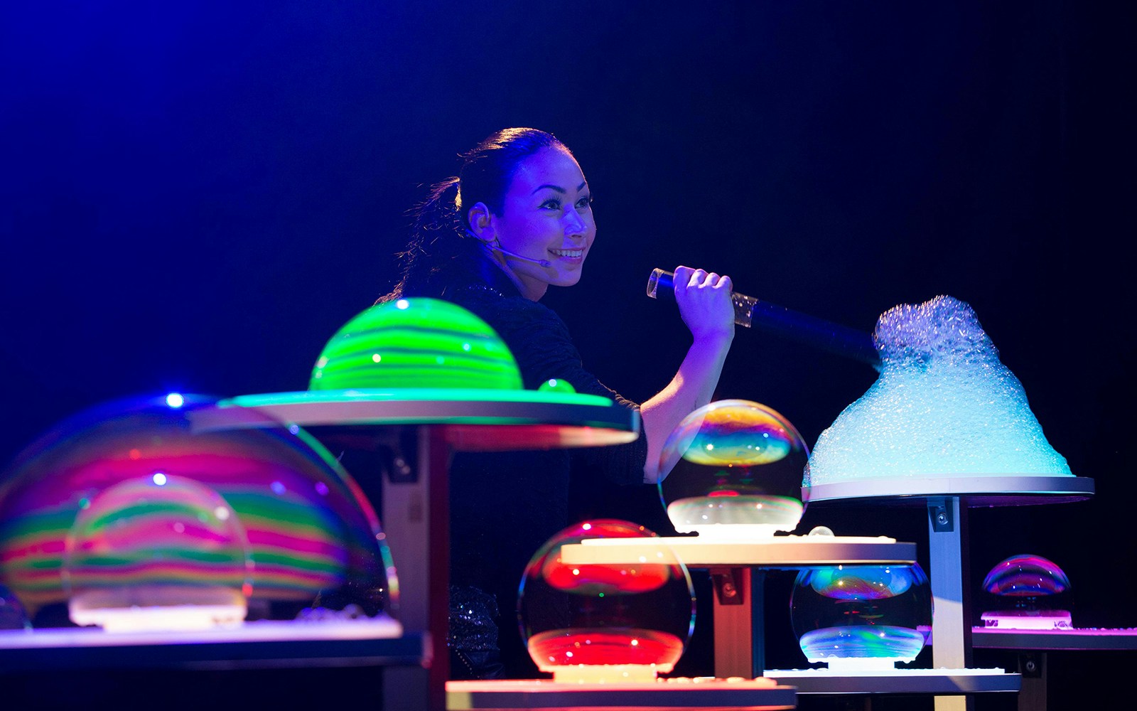 Performer creating colorful bubbles on stage at The Gazillion Bubble Show.