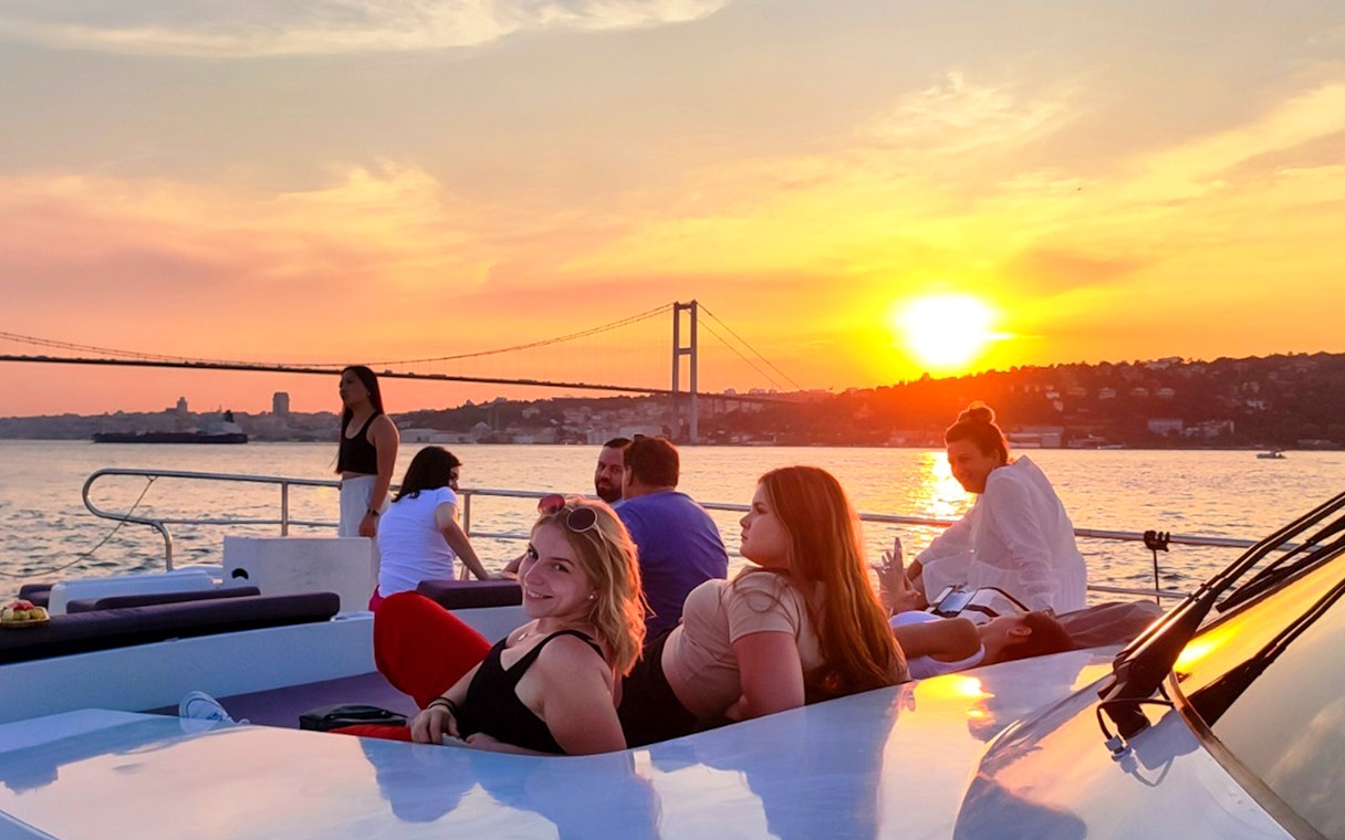People enjoying a sunset view on a boat cruise along the Bosphorus in Istanbul.