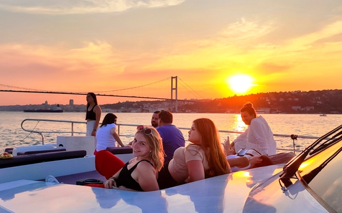 People enjoying a sunset view on a boat cruise along the Bosphorus in Istanbul.