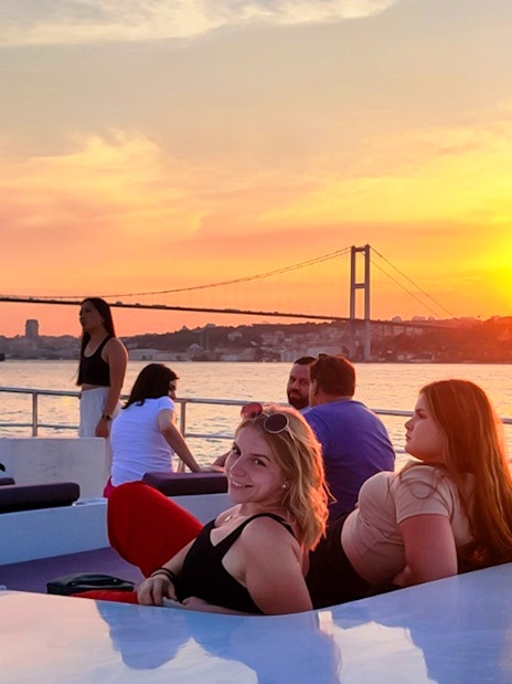 People enjoying a sunset view on a boat cruise along the Bosphorus in Istanbul.