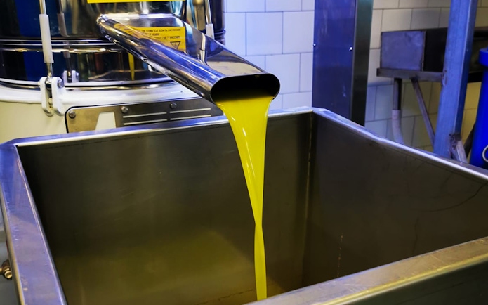 Olive oil flowing into a container during a Mount Etna tour with wine and olive oil tasting.