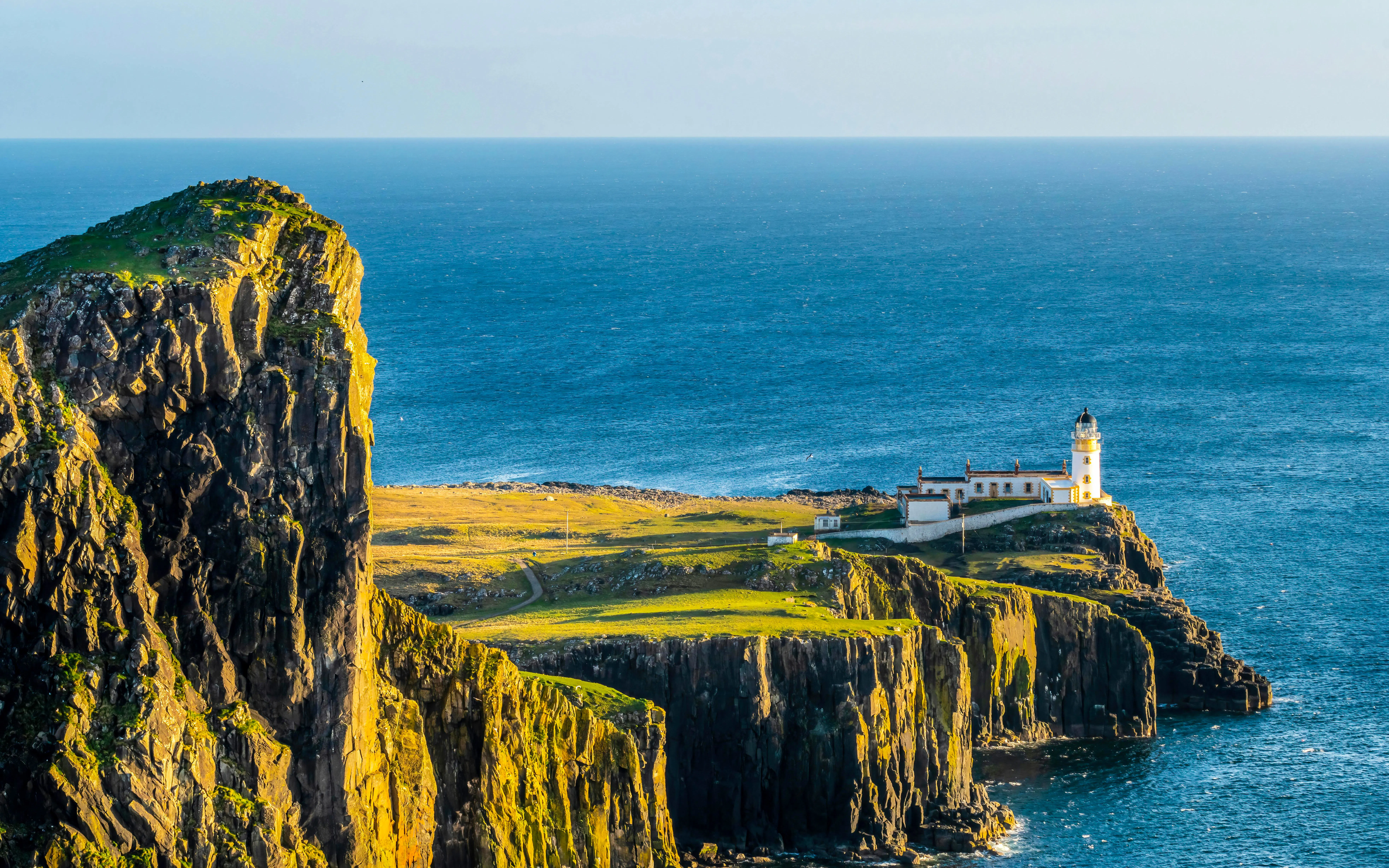 Neist Point Lighthouse on cliff overlooking ocean, Isle of Skye, Scotland.