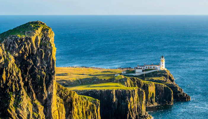 Neist Point Lighthouse on cliff overlooking ocean, Isle of Skye, Scotland.