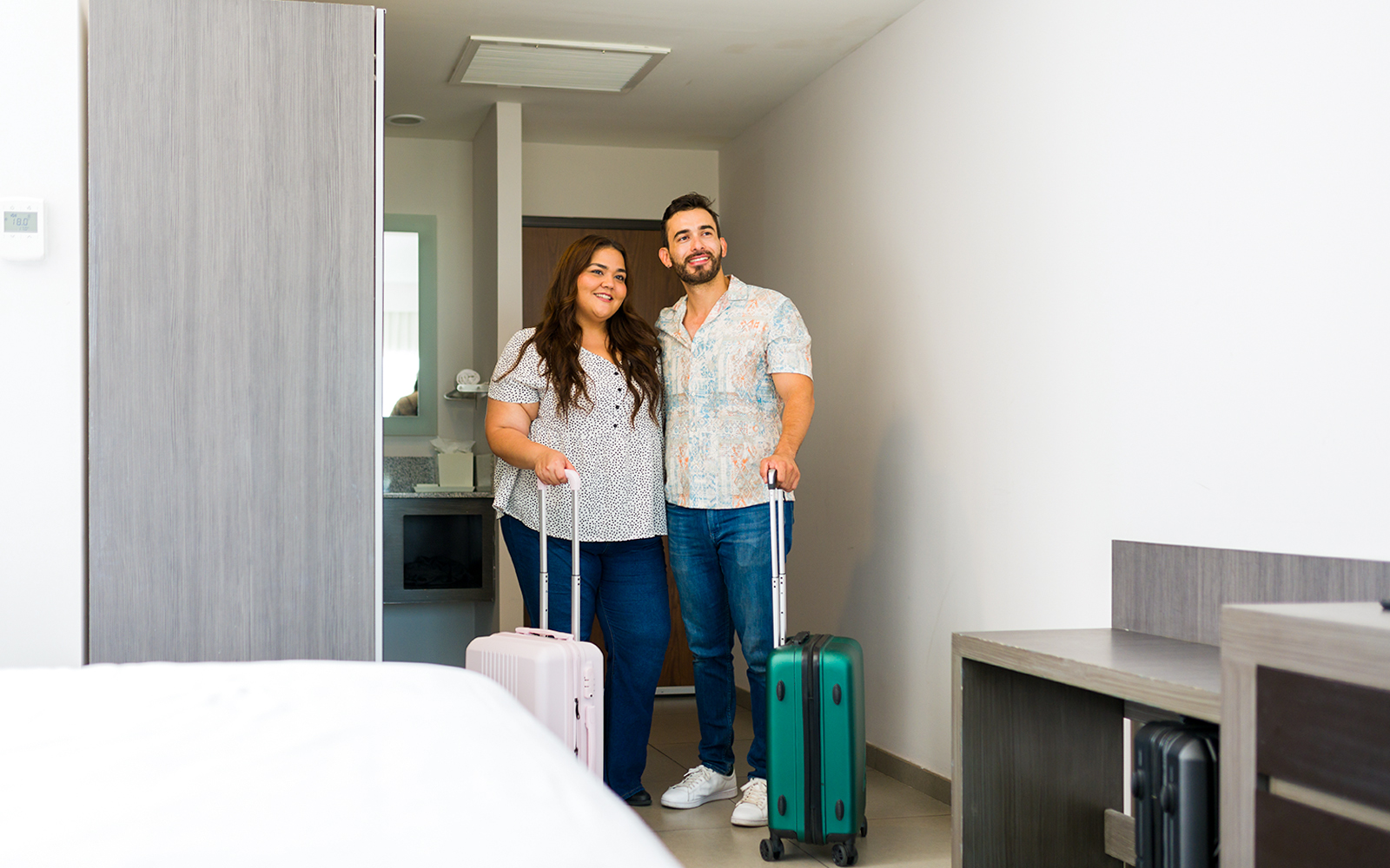 Young couple is entering their hotel room with their luggage