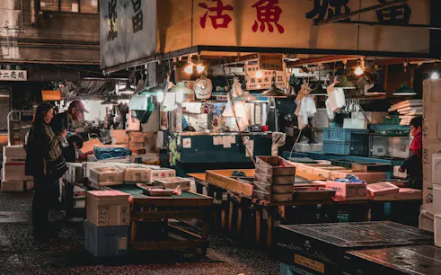 Visitors exploring a seafood market stall in Tsukiji, Tokyo during the Shitamachi Heritage Walking Tour.