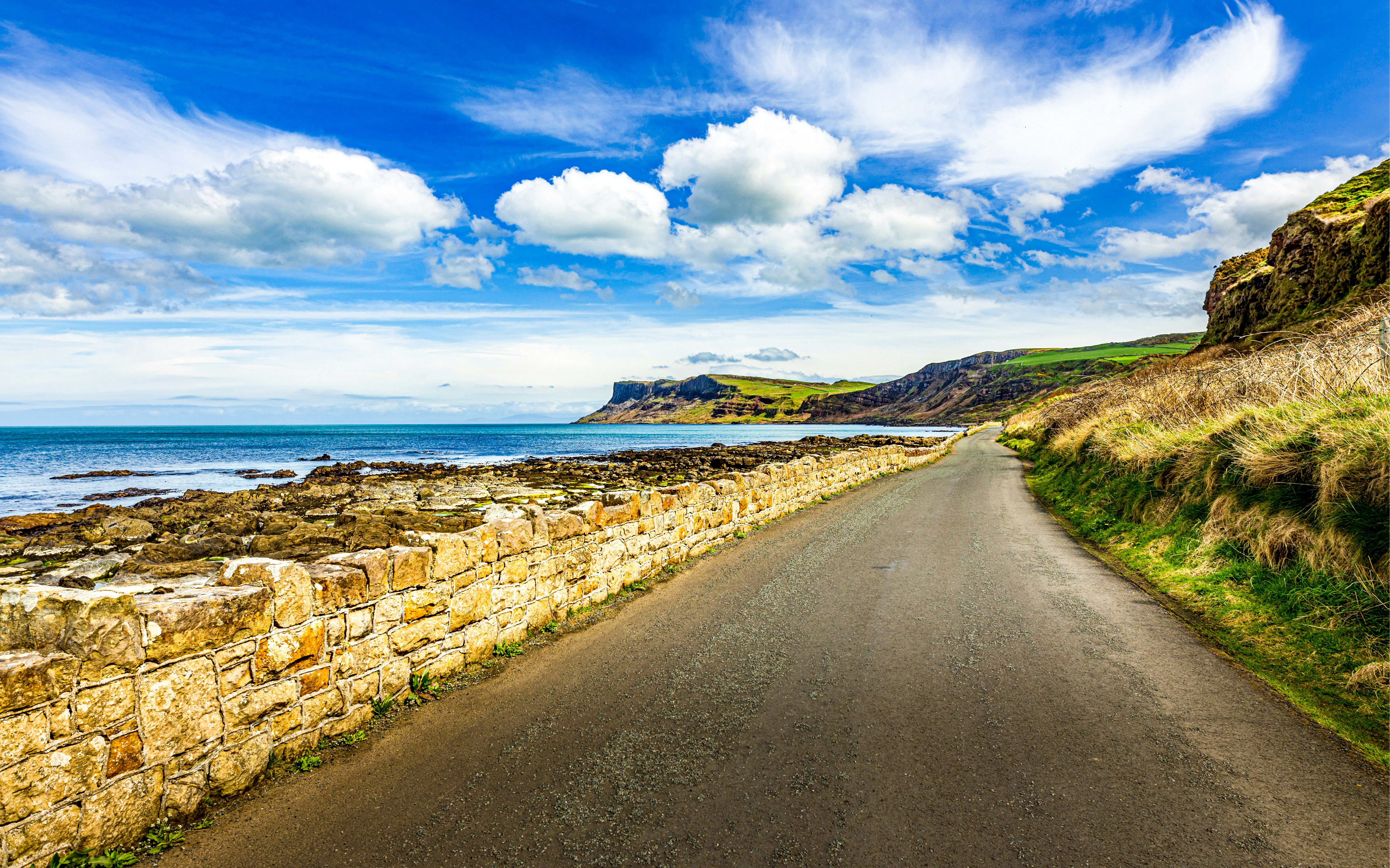 Coastal road along the glens in County Antrim, Northern Ireland, with ocean and cliffs.