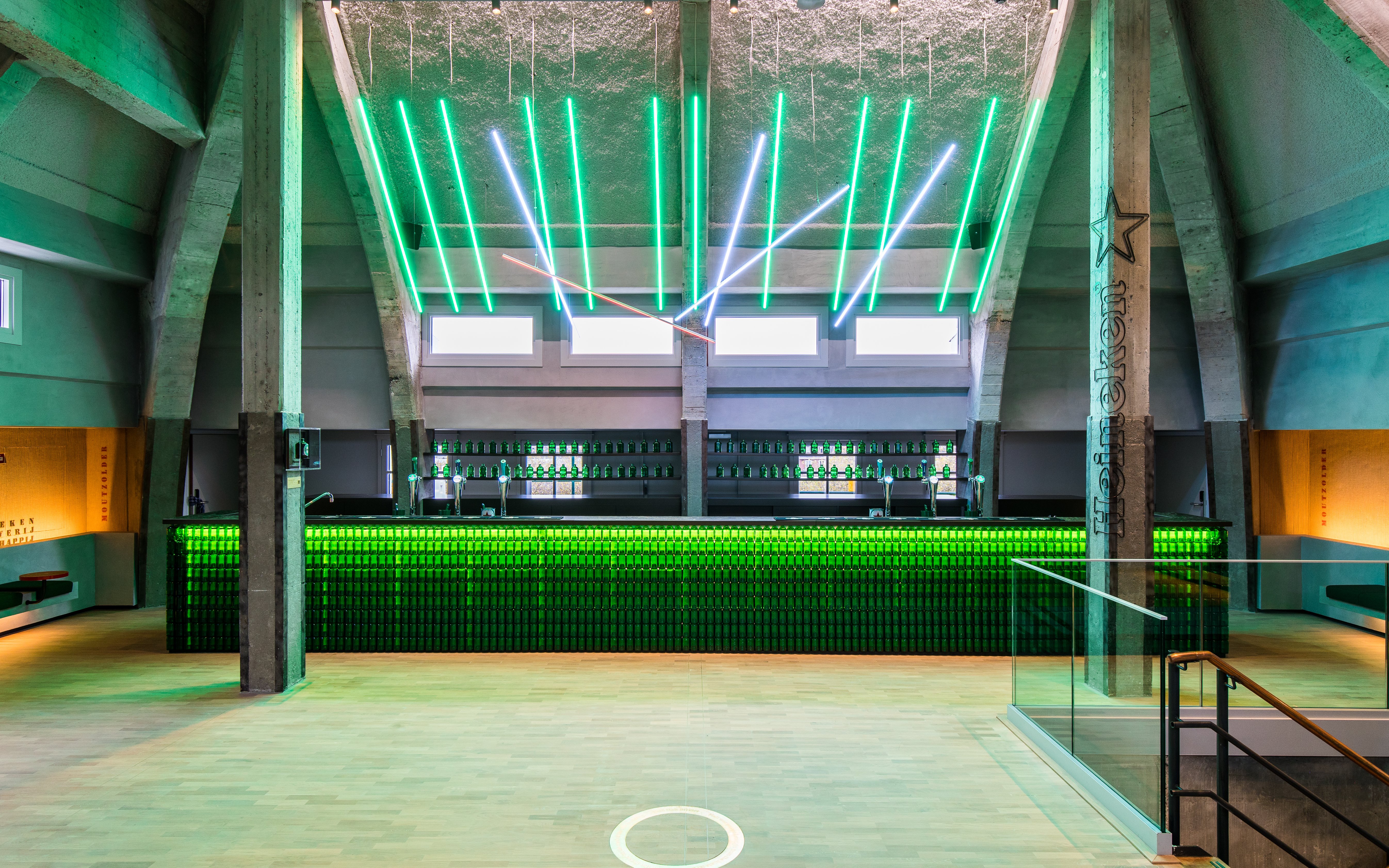 Heineken rooftop bar with green neon lights and bottle display in Amsterdam.