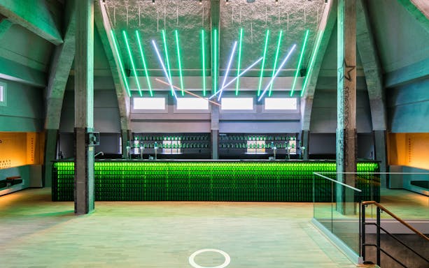 Heineken rooftop bar with green neon lights and bottle display in Amsterdam.