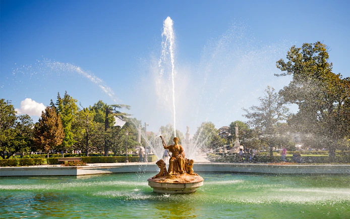Fountain in the gardens near the Royal Palace of Madrid with water spraying upward.