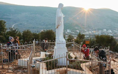 Pilgrims praying at Virgin Mary statue on Apparition Hill, Medjugorje, Bosnia and Herzegovina.