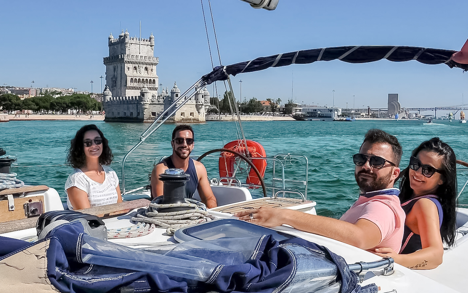 Tourists on a cruise boat near Belém Tower during a private Lisbon boat tour.