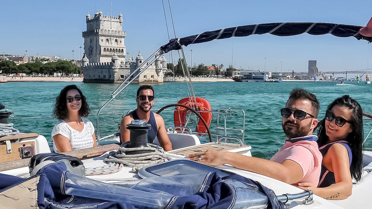 Tourists on a cruise boat near Belém Tower during a private Lisbon boat tour.