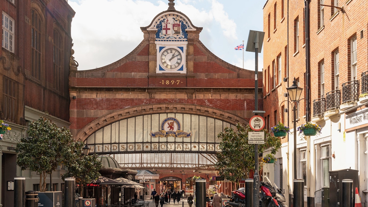 Windsor Castle railway station entrance with clock and shoppers.