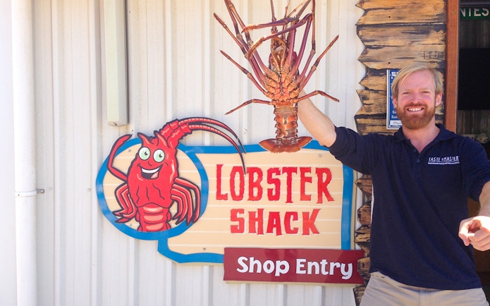 Lobster Shack entry sign with a person holding a large lobster, part of the Pinnacles tour from Perth.
