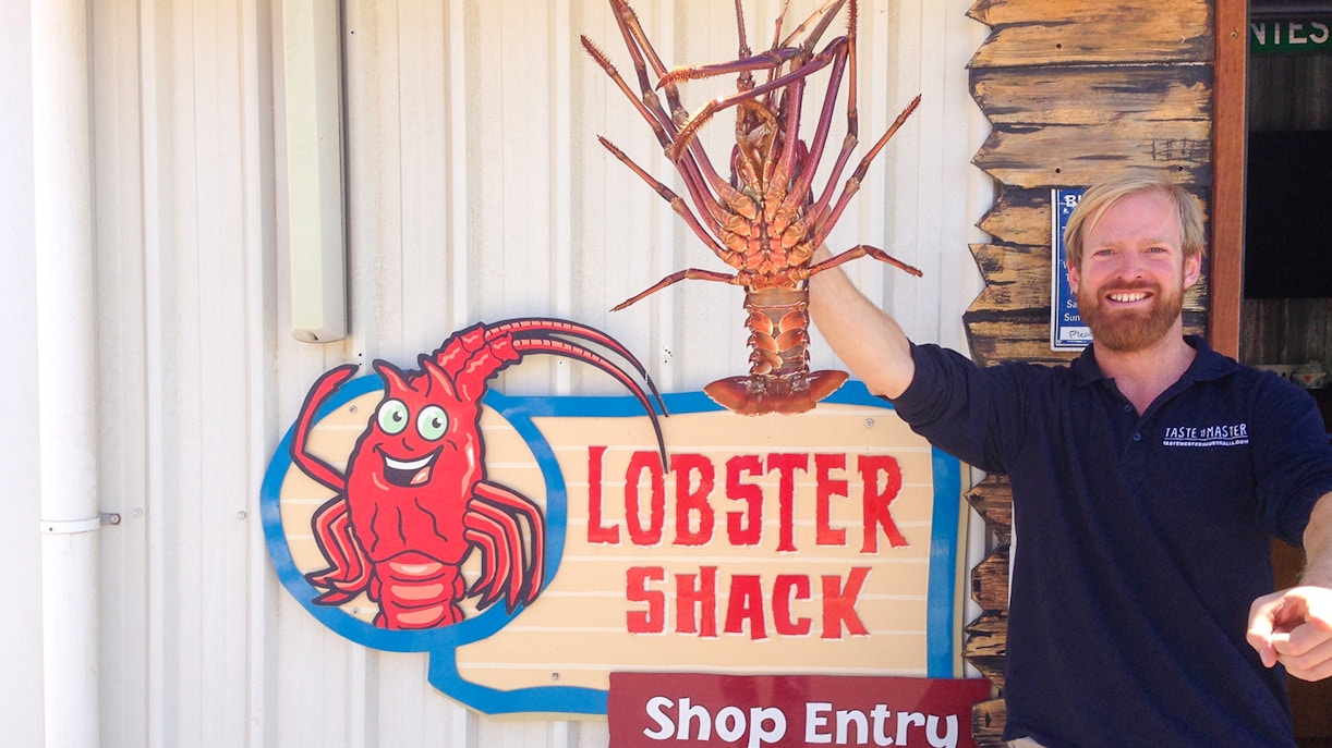 Lobster Shack entry sign with a person holding a large lobster, part of the Pinnacles tour from Perth.