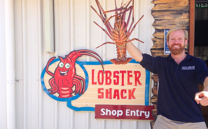 Lobster Shack entry sign with a person holding a large lobster, part of the Pinnacles tour from Perth.