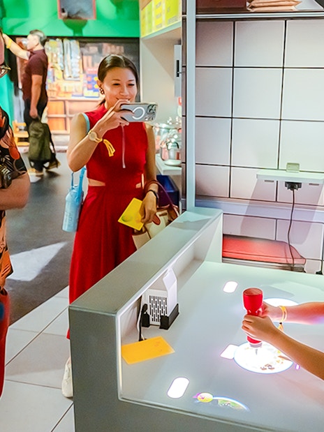 Family explores digital kitchen exhibit with interactive food projections.
