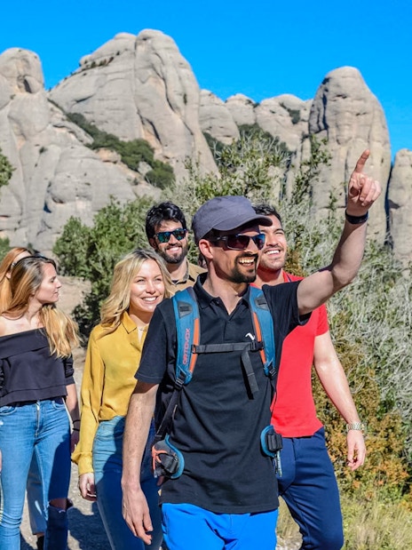 Tourists hiking with guide towards Montserrat Monastery in Spain.